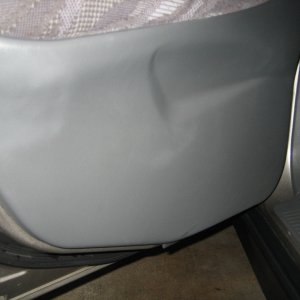 Lower grey plastic door panel before being cleaned