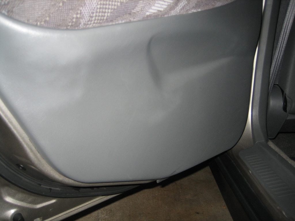 Lower grey plastic door panel before being cleaned